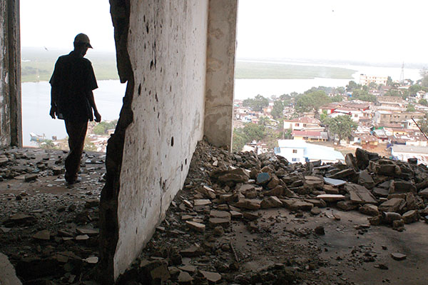 Man stands amid rubble in ruined tower. Photo by Danny Hoffman