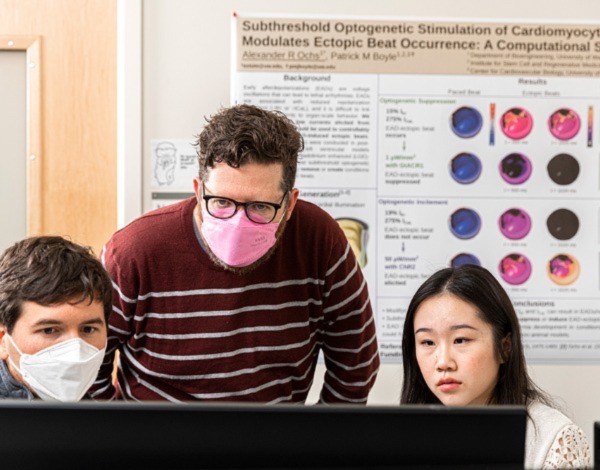 Patrick Boyle, center, with bioengineering Ph.D. candidate Alexander Ochs, left, and junior Jamie Yang, right, in the CardSS Lab looking at a computer screen