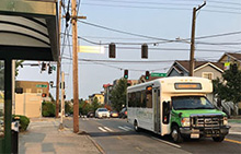 A private Microsoft shuttle drives past a King County Metro bus stop in North Seattle during the morning commute.