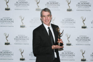 Eric Chudler holding an Emmy trophy.