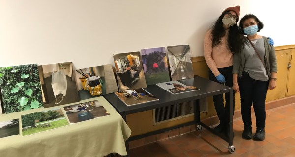 Evalina Romano and her mother standing next to tables displaying photos