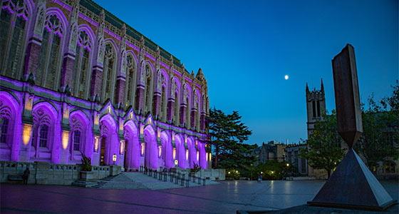 Suzzallo library illuminated in purple at night