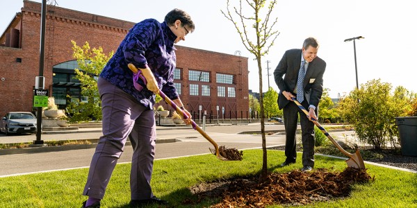 UW President Cauce and Gonzaga President McCulloh using shovels to plant a tree