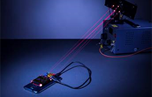 Wireless charging system created by UW engineers. Lasers are represented by red beams. Photo: Mark Stone/University of Washington
