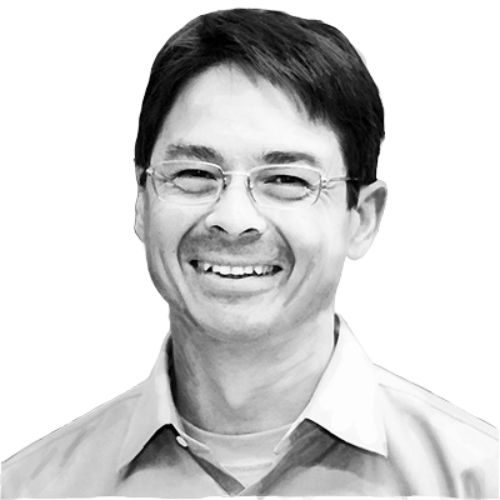 Sven Haakanson smiling at the camera, black and white photo